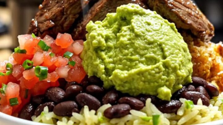 A close-up shot of shredded beef barbacoa in a black slow cooker, with steam rising and vibrant colors.