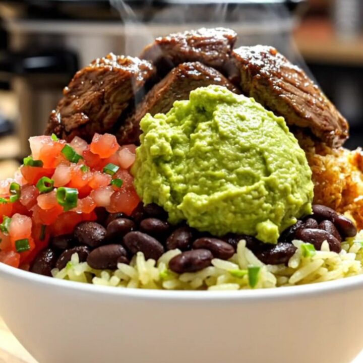 A close-up shot of shredded beef barbacoa in a black slow cooker, with steam rising and vibrant colors.