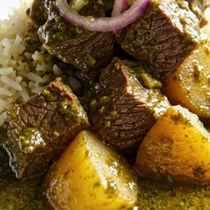 A ceramic slow cooker filled with tender beef chunks in a vibrant emerald-green cilantro sauce with potatoes.