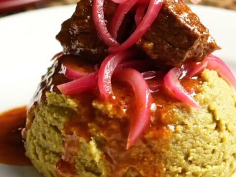 A glossy, rich Dominican Carne Guisada served in a ceramic Crockpot with steam rising.