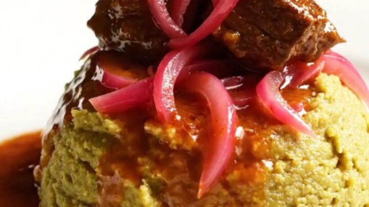 A glossy, rich Dominican Carne Guisada served in a ceramic Crockpot with steam rising.