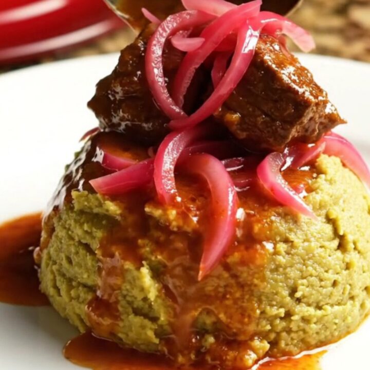 A glossy, rich Dominican Carne Guisada served in a ceramic Crockpot with steam rising.