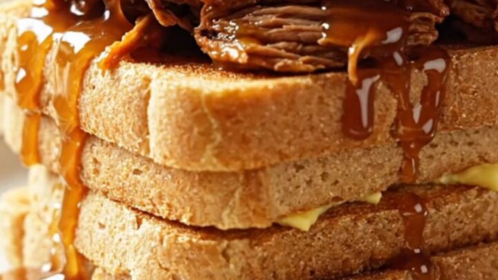 Extreme close-up of a fork shredding tender maple chipotle brisket in a dark