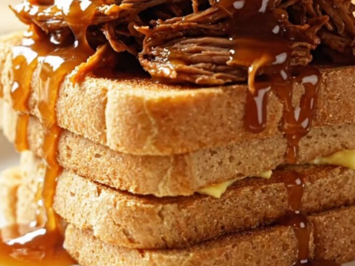 Extreme close-up of a fork shredding tender maple chipotle brisket in a dark