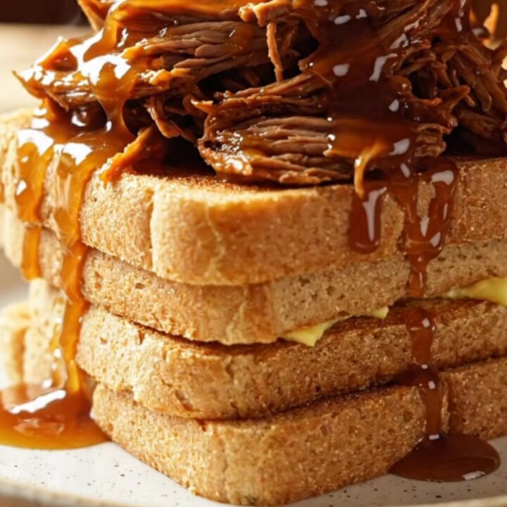 Extreme close-up of a fork shredding tender maple chipotle brisket in a dark