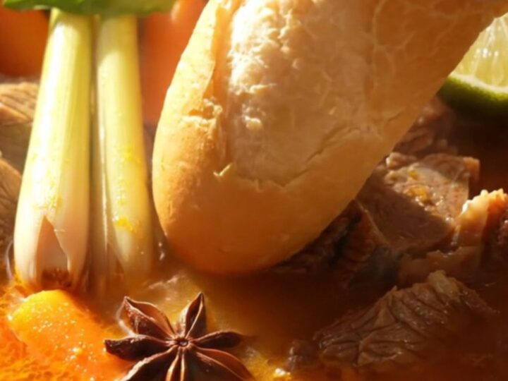 A steaming bowl of Vietnamese Bo Kho beef stew with carrots and fresh Thai basil.