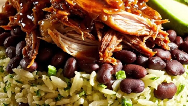 A vibrant burrito bowl featuring shredded chipotle honey lime chicken, black beans, avocado, and cilantro rice.