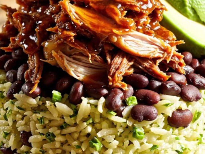 A vibrant burrito bowl featuring shredded chipotle honey lime chicken, black beans, avocado, and cilantro rice.