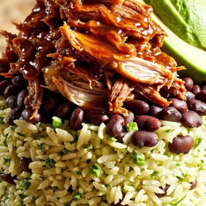 A vibrant burrito bowl featuring shredded chipotle honey lime chicken, black beans, avocado, and cilantro rice.