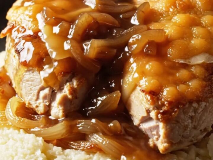 A close-up of Crockpot French Onion Gruyere Chicken with melted cheese and caramelized onions.
