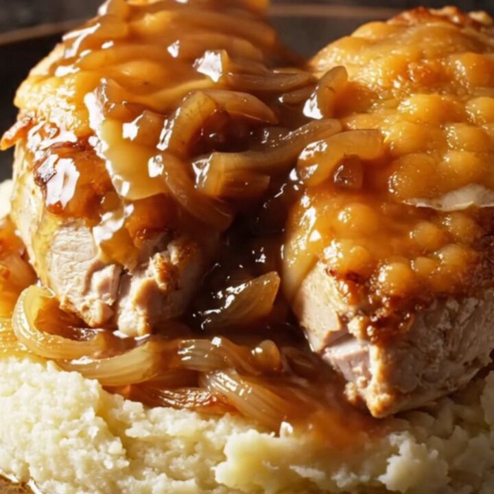 A close-up of Crockpot French Onion Gruyere Chicken with melted cheese and caramelized onions.