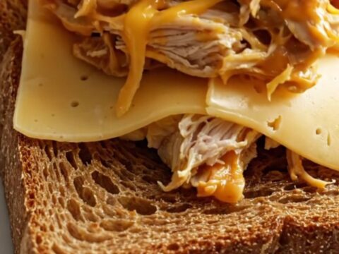 Close up of shredded creamy Reuben chicken piled on toasted rye bread.