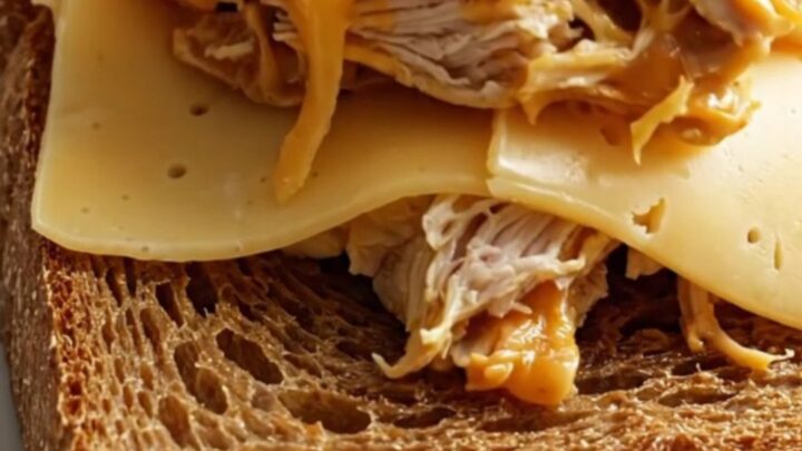 Close up of shredded creamy Reuben chicken piled on toasted rye bread.