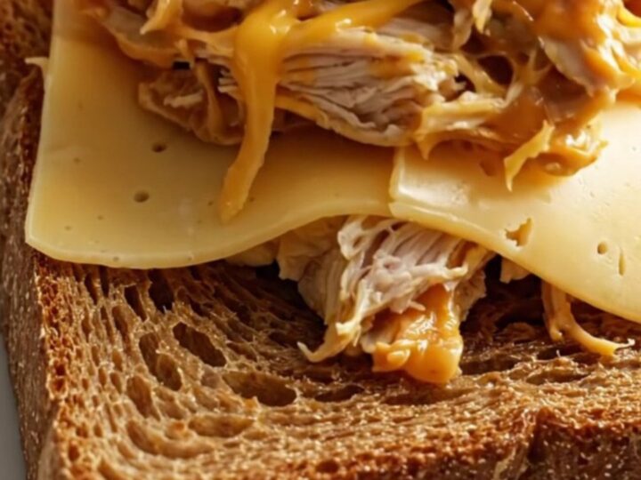 Close up of shredded creamy Reuben chicken piled on toasted rye bread.