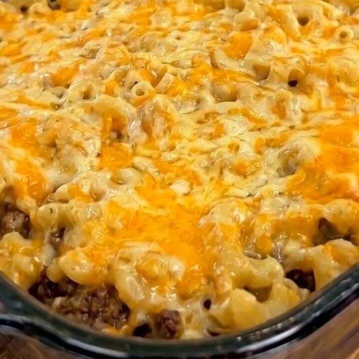 A portion of mac and cheese meatloaf casserole being lifted with a spatula, showing an epic cheese pull.