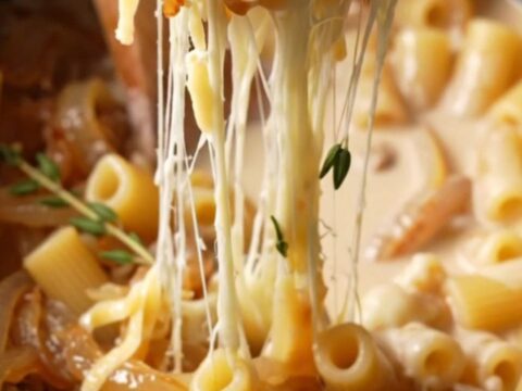 Close-up of creamy campanelle pasta with caramelized onions and stretchy melted Gruyere cheese.