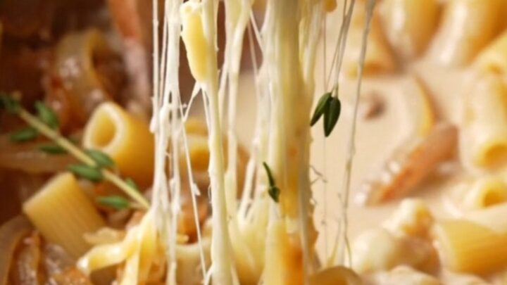 Close-up of creamy campanelle pasta with caramelized onions and stretchy melted Gruyere cheese.