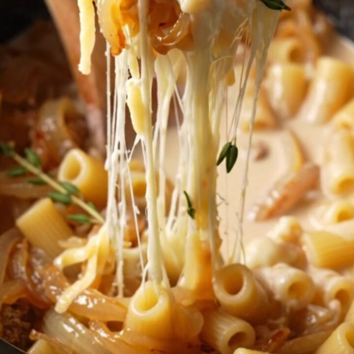 Close-up of creamy campanelle pasta with caramelized onions and stretchy melted Gruyere cheese.