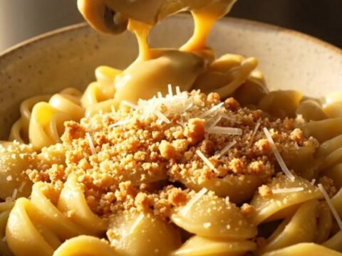A close-up of orecchiette pasta tossed in a creamy garlic and mushroom sauce, served in a slate-gray bowl.