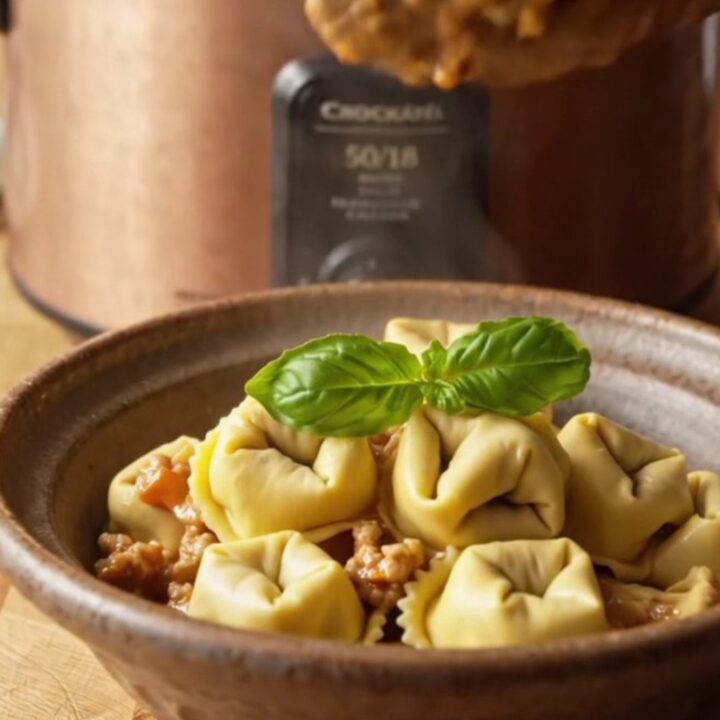 A close-up of a bowl filled with creamy turkey, zucchini, and three-cheese tortellini in a rich parmesan tomato sauce.