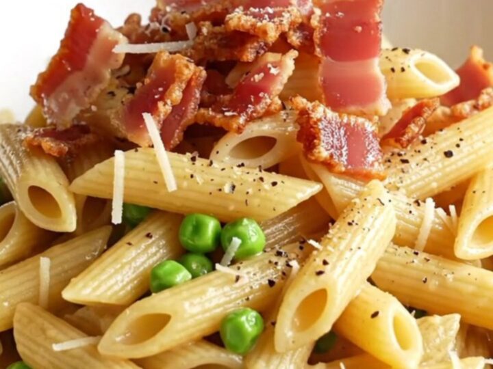 A steaming bowl of creamy Boursin chicken carbonara topped with crispy pancetta and black pepper.