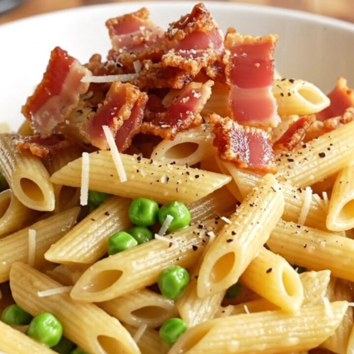 A steaming bowl of creamy Boursin chicken carbonara topped with crispy pancetta and black pepper.