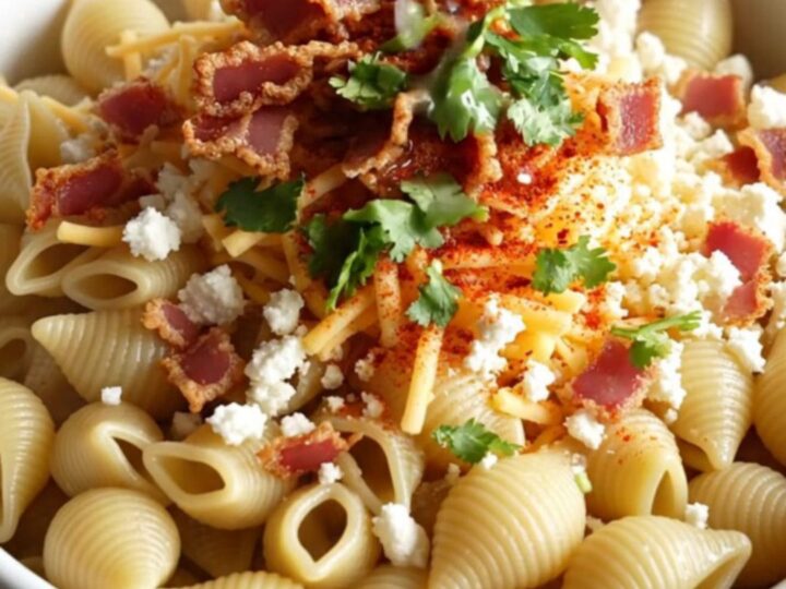 A steaming bowl of creamy Mexican street corn pasta topped with crispy bacon, fresh cilantro, and a dusting of Tajín.