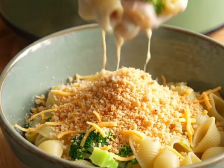 A steaming bowl of creamy pasta shells with smoked ham and broccoli, topped with buttery toasted crumbs.