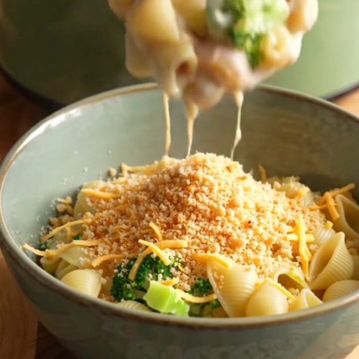 A steaming bowl of creamy pasta shells with smoked ham and broccoli, topped with buttery toasted crumbs.