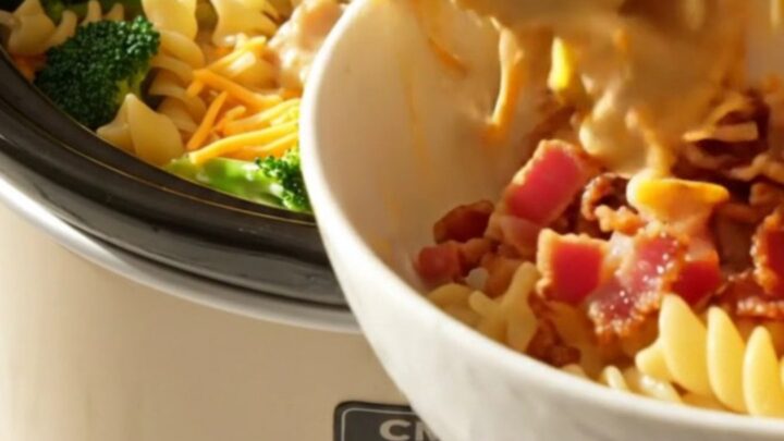 A close-up view of the creamy crockpot chicken, broccoli, and rotini pasta topped with crispy bacon bits.