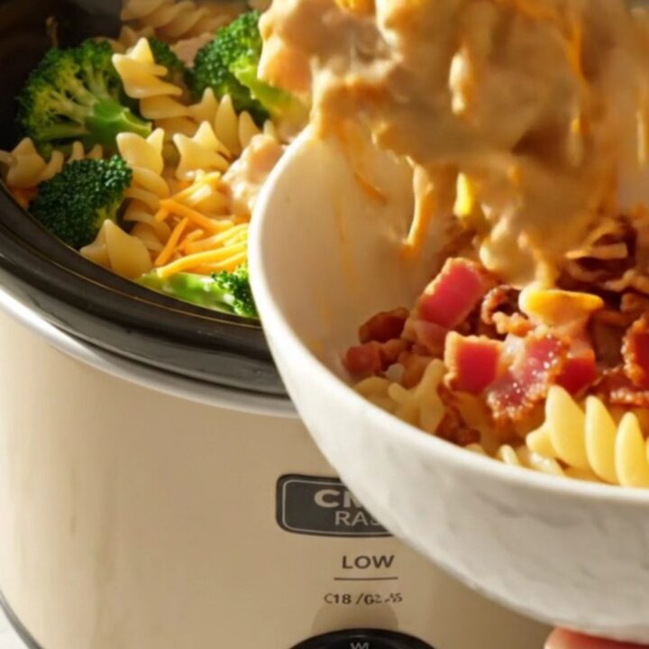 A close-up view of the creamy crockpot chicken, broccoli, and rotini pasta topped with crispy bacon bits.