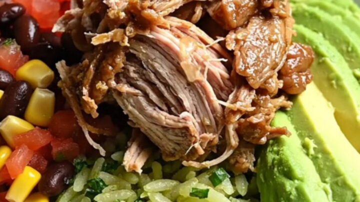 A close-up of a burrito bowl featuring smoky shredded chipotle honey pork, black beans, corn, and avocado.