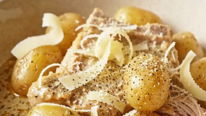 A close-up of tender pork chops and golden baby potatoes coated in a thick