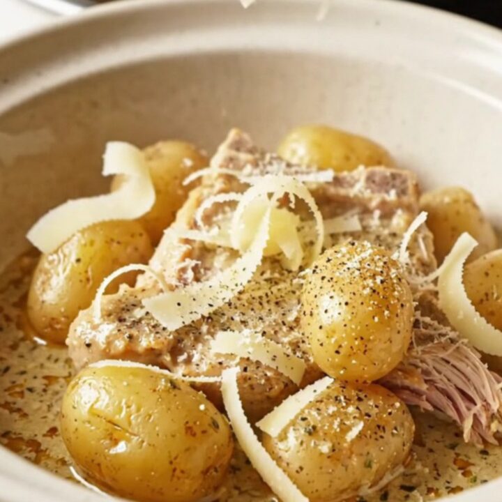 A close-up of tender pork chops and golden baby potatoes coated in a thick