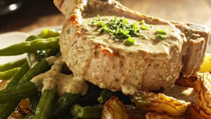 Close up of creamy Dijon mustard and tarragon pork chops in a slow cooker with steam rising.