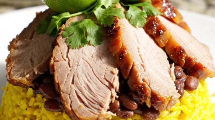 A white ceramic slow cooker filled with tender Cuban roast pork loin and savory black beans.