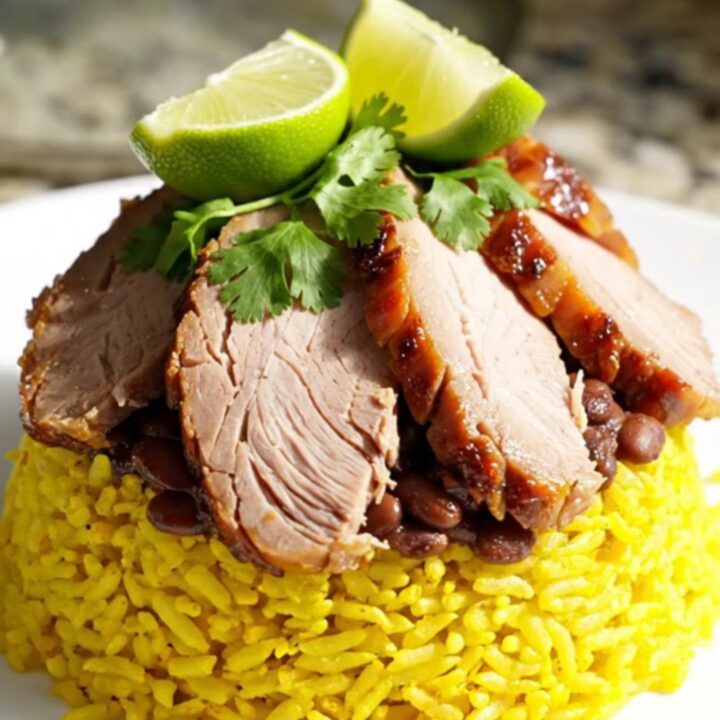 A white ceramic slow cooker filled with tender Cuban roast pork loin and savory black beans.