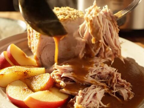 A succulent slow-cooked pork loin topped with a caramelized brown sugar and mustard crust, served with tender baked apples.