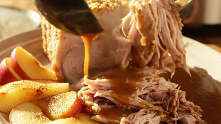 A succulent slow-cooked pork loin topped with a caramelized brown sugar and mustard crust, served with tender baked apples.