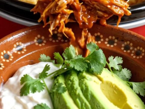 A warm Crockpot filled with golden-brown cornbread-topped pulled pork casserole.