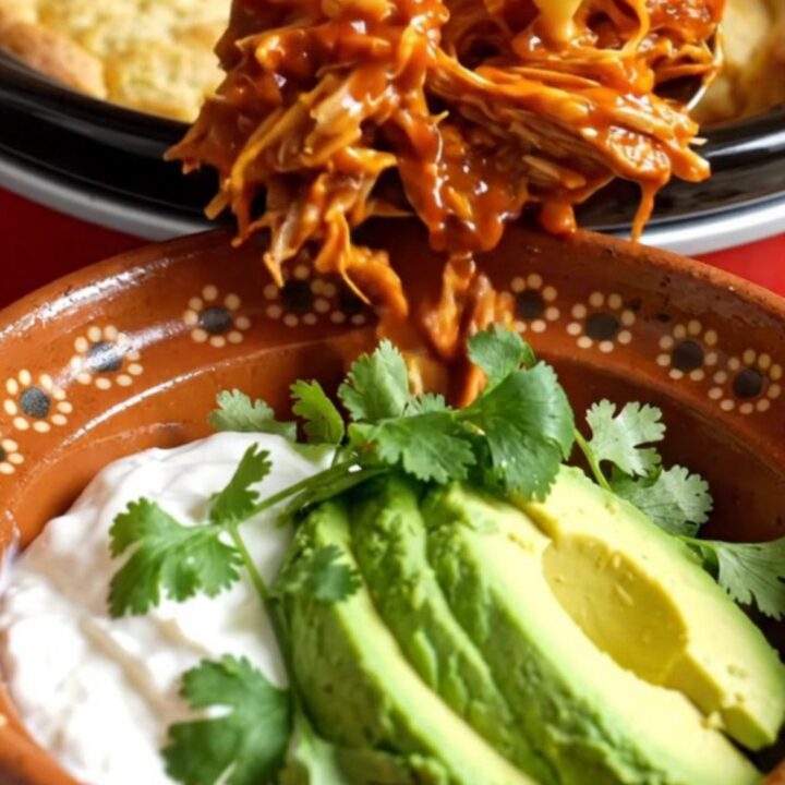 A warm Crockpot filled with golden-brown cornbread-topped pulled pork casserole.