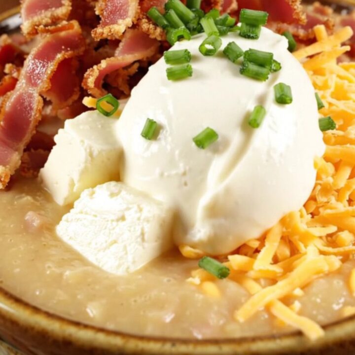A steaming bowl of creamy loaded baked potato chowder topped with crispy bacon, cheddar, and chives.