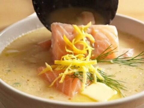 A close-up of a matte-slate ceramic slow cooker filled with creamy Nordic salmon and potato chowder.