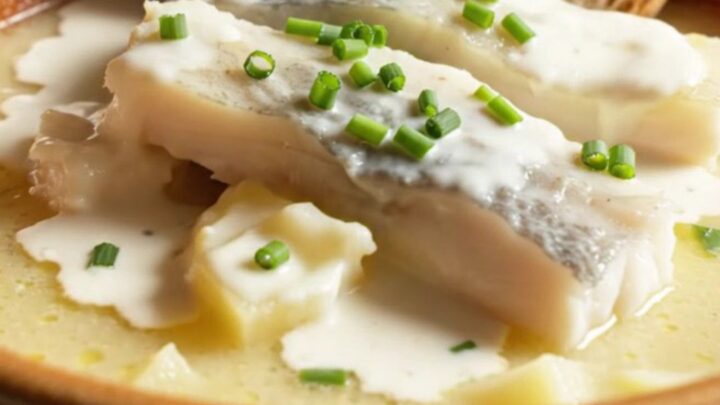 A warm stoneware bowl filled with creamy, ivory-gold smoked haddock chowder, topped with chives and served with crusty bread.