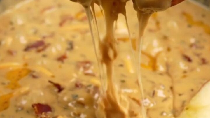 A creamy, molten smoked gouda and bacon dip served in a ceramic slow cooker with crusty bread and apple slices.