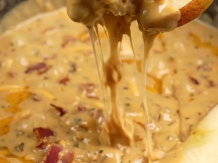 A creamy, molten smoked gouda and bacon dip served in a ceramic slow cooker with crusty bread and apple slices.