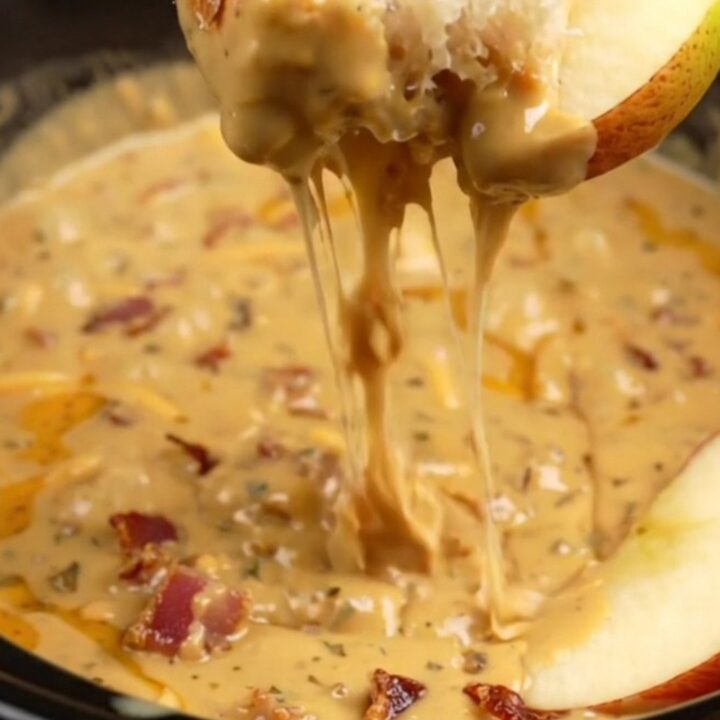A creamy, molten smoked gouda and bacon dip served in a ceramic slow cooker with crusty bread and apple slices.
