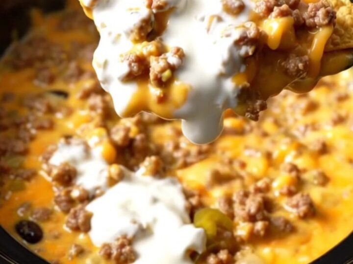 Extreme close-up of a tortilla chip being dipped into a bubbling