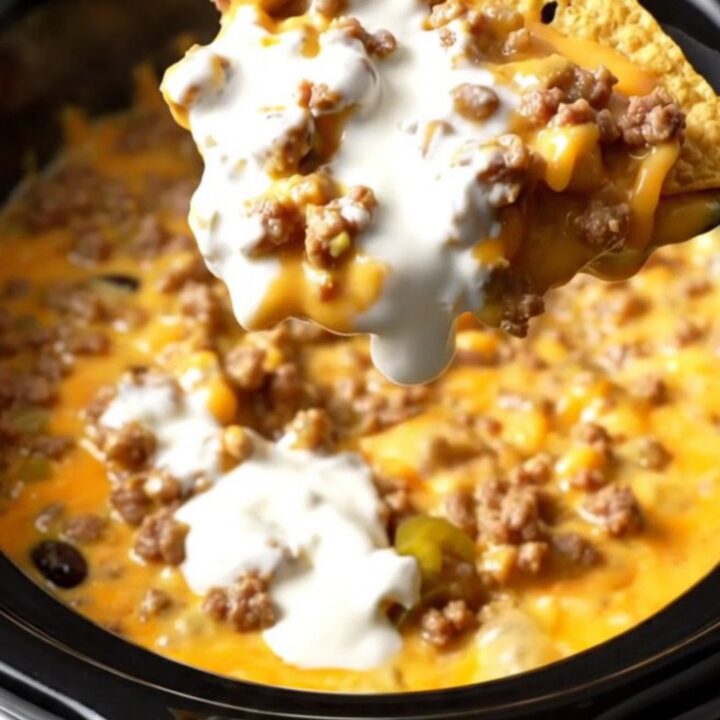Extreme close-up of a tortilla chip being dipped into a bubbling