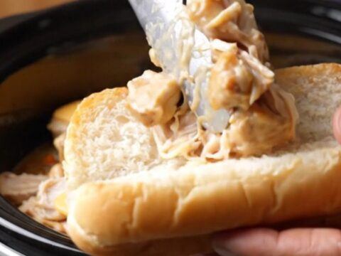 A close-up of creamy Philly cheesesteak chicken in a toasted hoagie roll with melted provolone cheese.